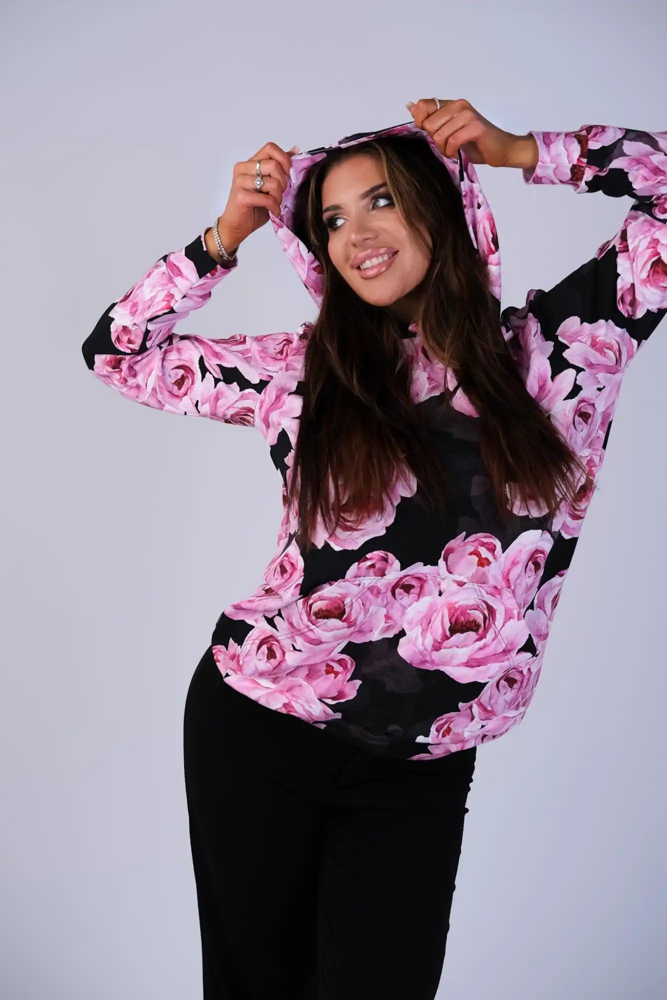 Musta huppariosainen collegepaita, jossa on vaaleanpunainen ruusukuvio.