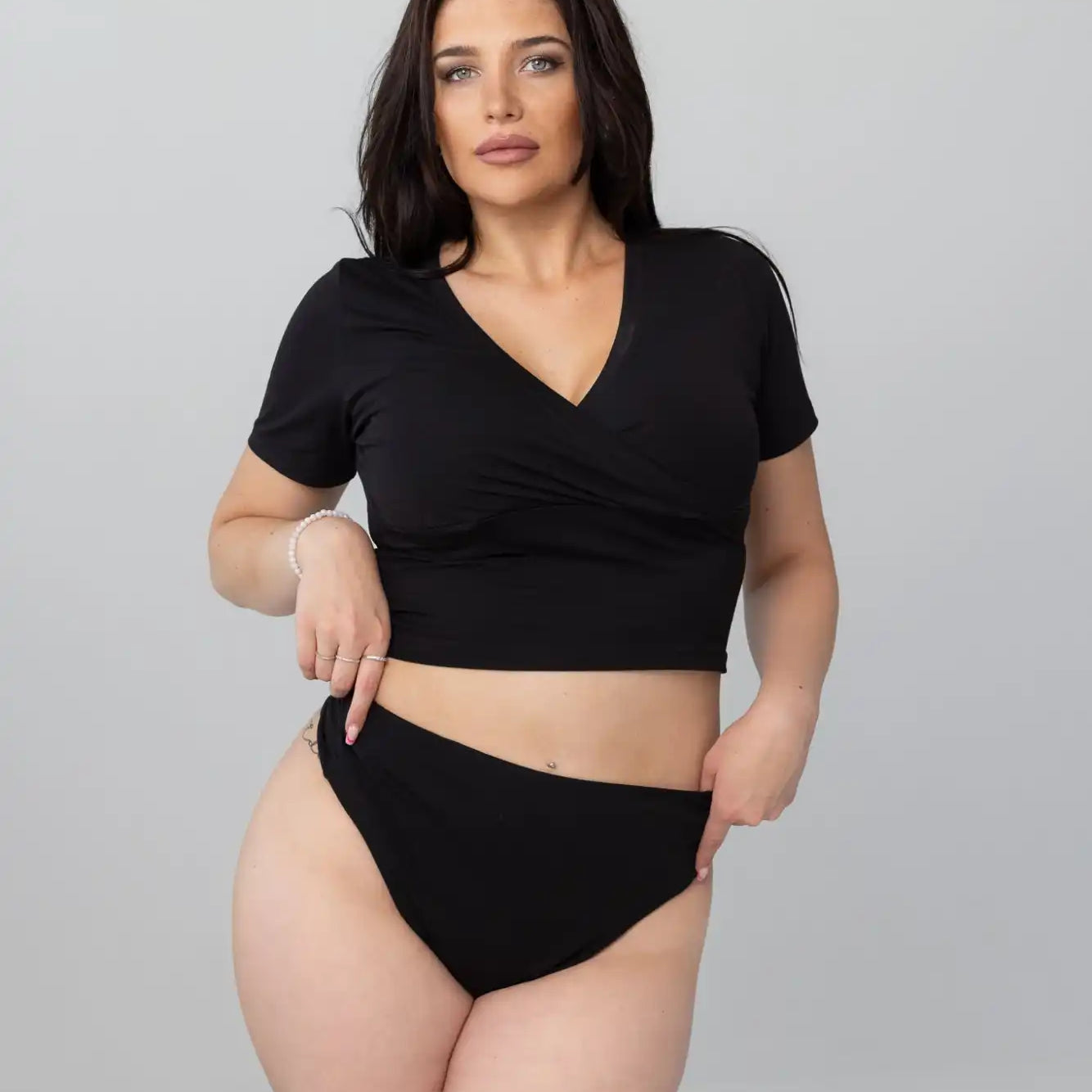 Mustavalkoinen V-pääntainen crop-top korkeavyötäröisillä bikineillä.